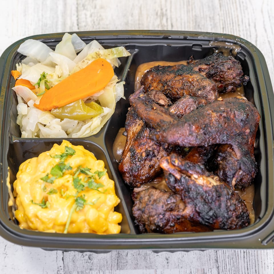 St. Bess Jerk meal with dark jerk chicken, mac and cheese, and steamed cabbage with carrots.